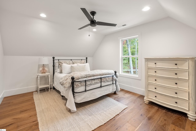 bedroom with baseboards, visible vents, wood finished floors, vaulted ceiling, and recessed lighting