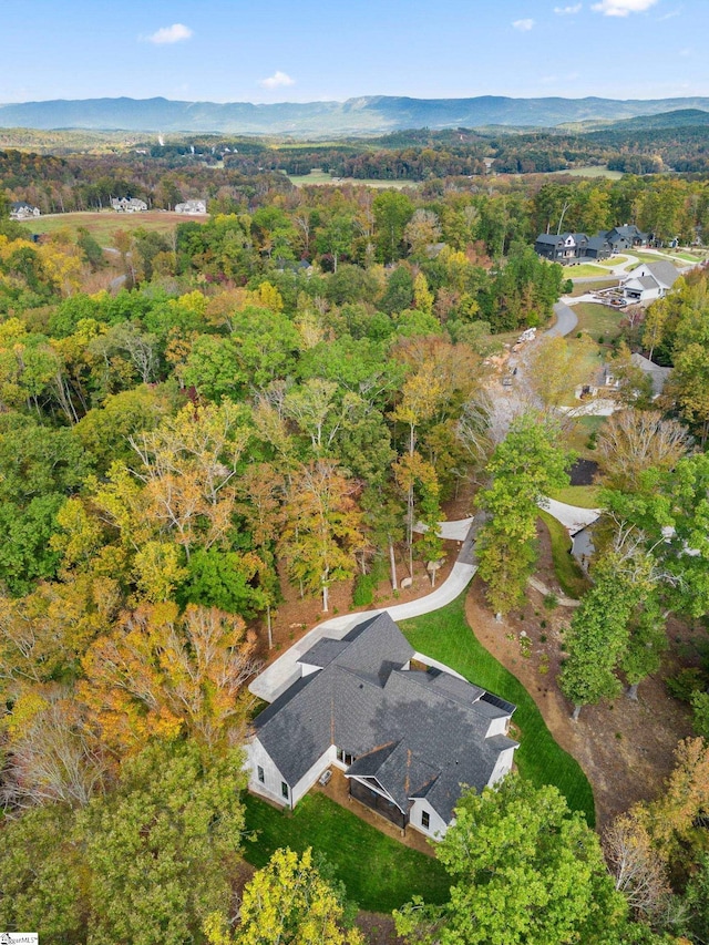 drone / aerial view featuring a mountain view and a view of trees