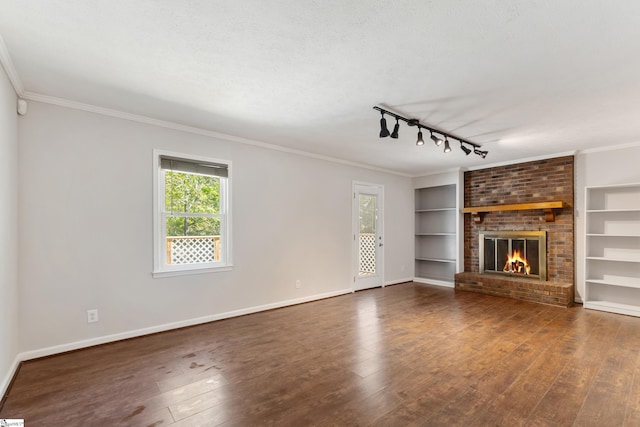 unfurnished living room featuring built in features, baseboards, ornamental molding, and dark wood-type flooring