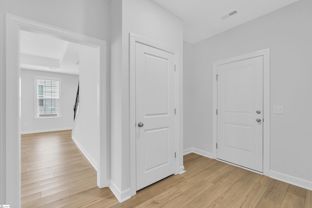 entryway with baseboards, visible vents, and light wood finished floors