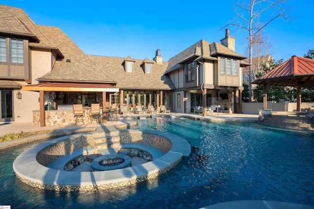 view of swimming pool with a gazebo, a pool with connected hot tub, outdoor dry bar, and a patio