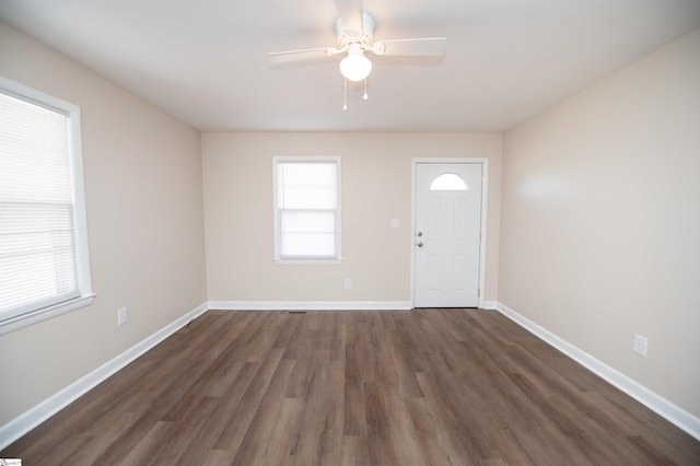 foyer featuring ceiling fan, baseboards, and dark wood-type flooring