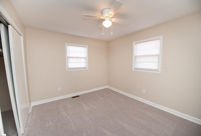 unfurnished bedroom featuring visible vents, baseboards, a ceiling fan, carpet flooring, and a closet