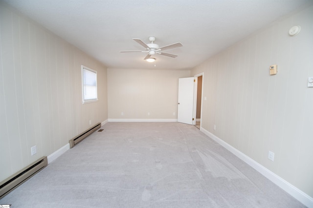 carpeted spare room featuring baseboards, baseboard heating, and a ceiling fan