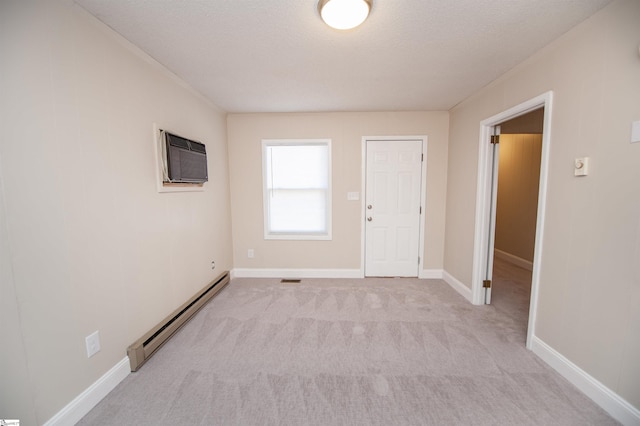 unfurnished room featuring baseboards, light colored carpet, a wall mounted air conditioner, baseboard heating, and a textured ceiling