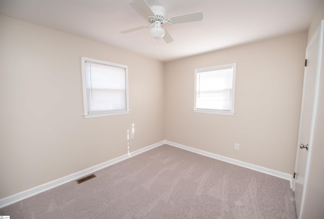 unfurnished room with carpet, baseboards, visible vents, and ceiling fan