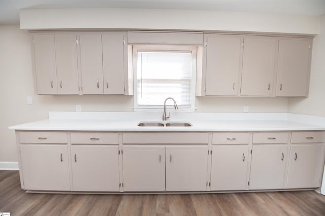 kitchen with light countertops, a sink, and light wood-style floors