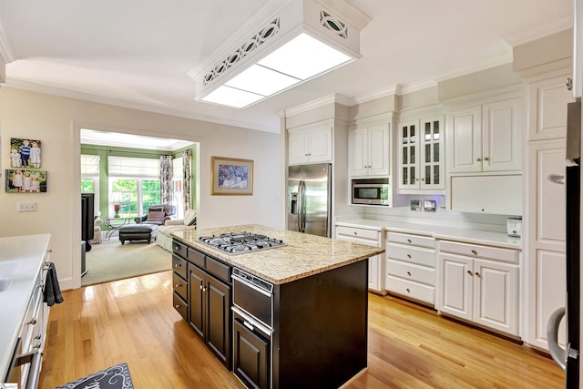 kitchen featuring a warming drawer, light wood-style flooring, appliances with stainless steel finishes, ornamental molding, and white cabinetry