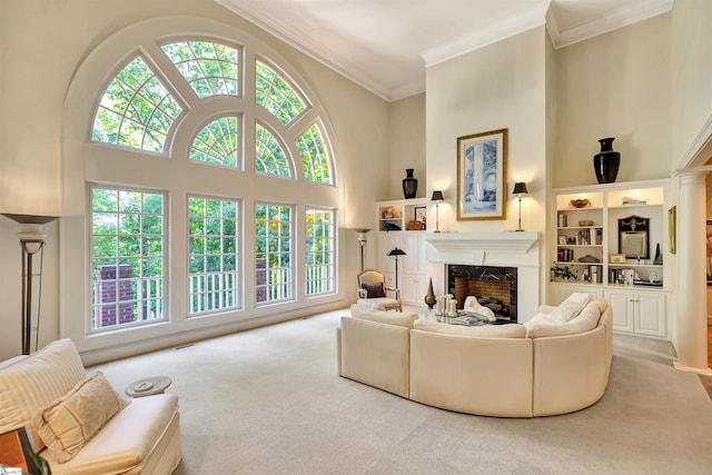 carpeted living room featuring crown molding, visible vents, a fireplace, and a towering ceiling