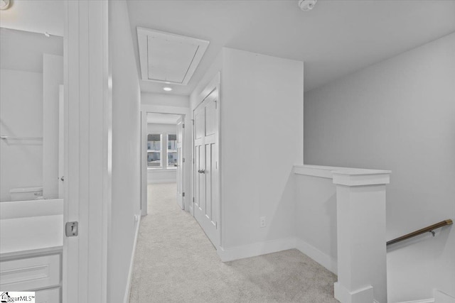 hall featuring baseboards, carpet floors, an upstairs landing, and attic access