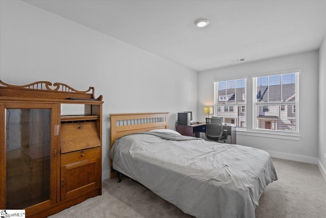 bedroom with baseboards, visible vents, and light colored carpet