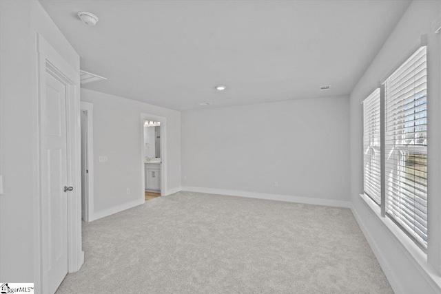 empty room with baseboards and light colored carpet