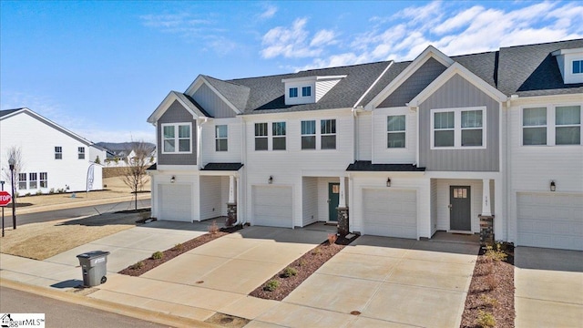 view of property featuring driveway, an attached garage, and board and batten siding