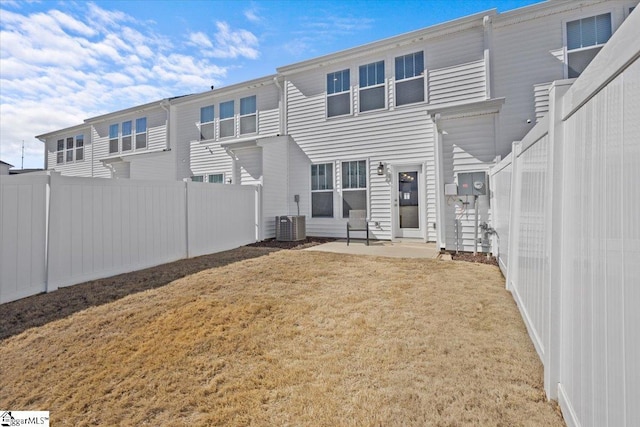 back of house with a patio area, a fenced backyard, central AC, and a lawn