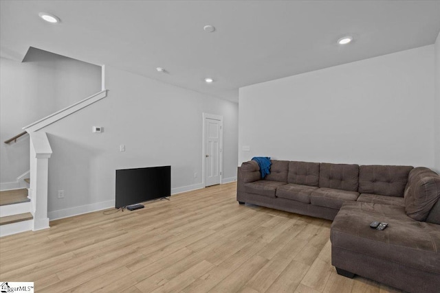 living room with baseboards, light wood finished floors, stairway, and recessed lighting