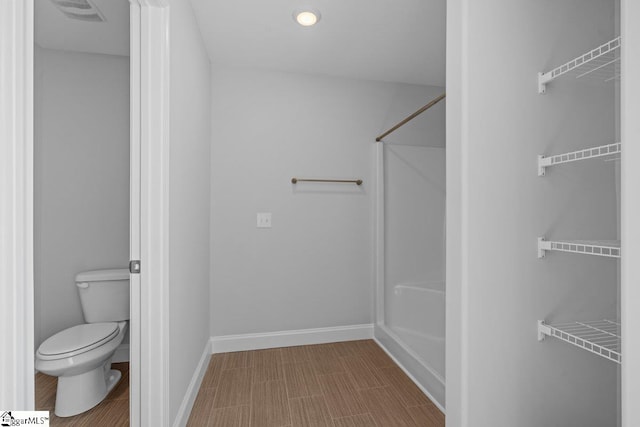 full bath featuring visible vents, toilet, baseboards, and walk in shower