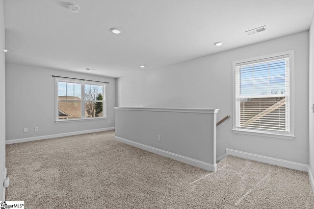 carpeted empty room with recessed lighting, visible vents, and baseboards