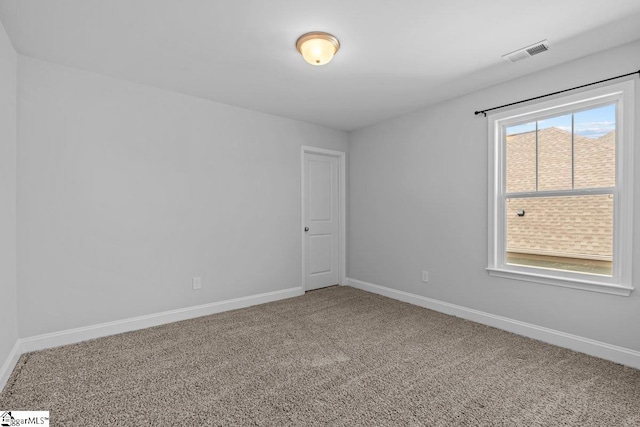 carpeted empty room featuring baseboards and visible vents