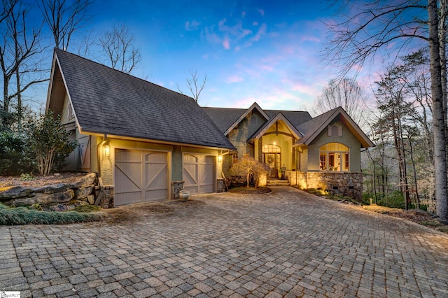 view of front of home with stone siding and decorative driveway