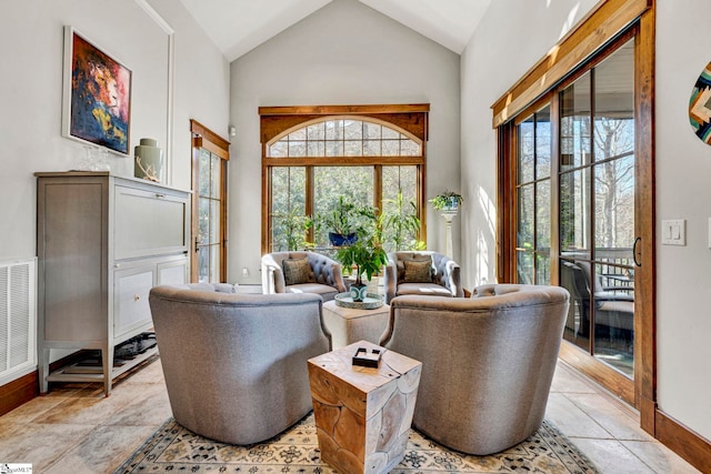 interior space featuring high vaulted ceiling, baseboards, and visible vents