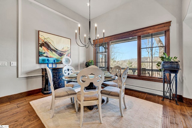 dining space featuring a notable chandelier, baseboards, baseboard heating, and hardwood / wood-style floors