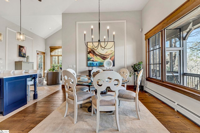 dining area with high vaulted ceiling, a baseboard radiator, a notable chandelier, and hardwood / wood-style flooring