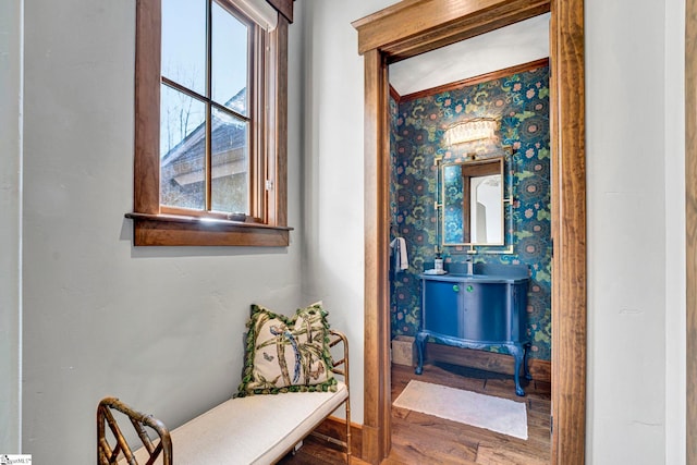 bathroom featuring wallpapered walls, wood finished floors, and vanity