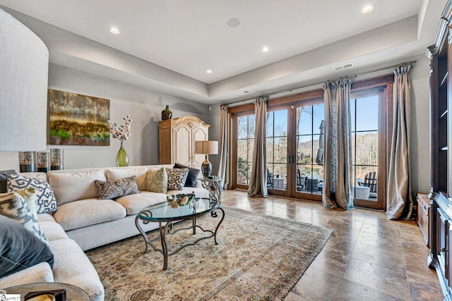 living area with a tray ceiling, french doors, visible vents, and recessed lighting