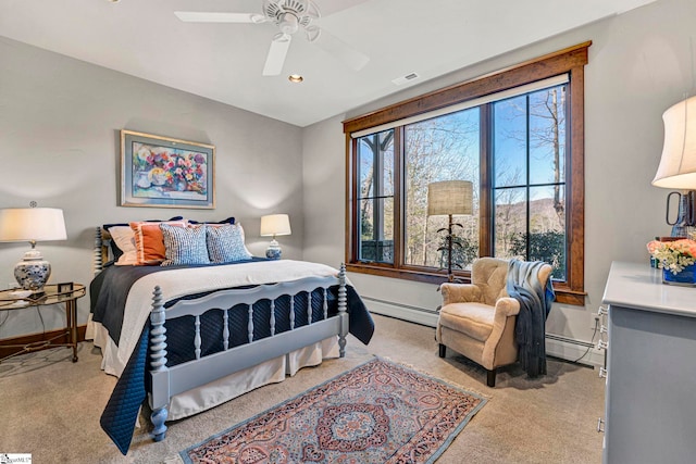 bedroom with a baseboard heating unit, carpet floors, multiple windows, and visible vents