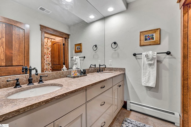 bathroom featuring a baseboard heating unit, visible vents, a sink, and double vanity