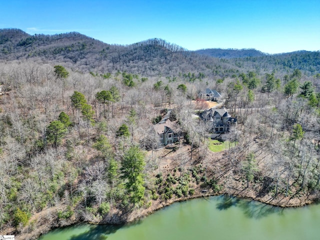 drone / aerial view with a forest view and a water and mountain view