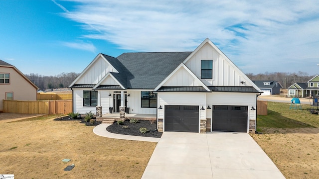 modern farmhouse with board and batten siding, a standing seam roof, metal roof, fence, and driveway