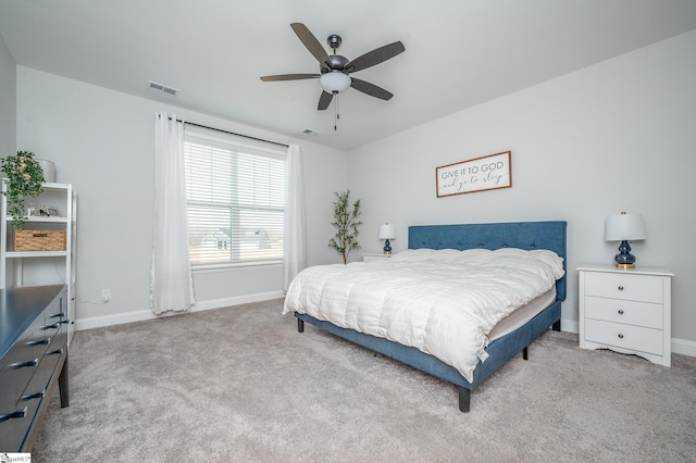 carpeted bedroom featuring a ceiling fan, visible vents, and baseboards