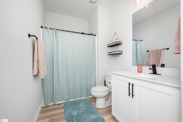 bathroom featuring toilet, a shower with shower curtain, wood finished floors, and vanity