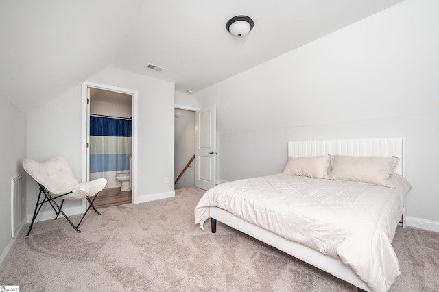 bedroom with vaulted ceiling, carpet flooring, and visible vents