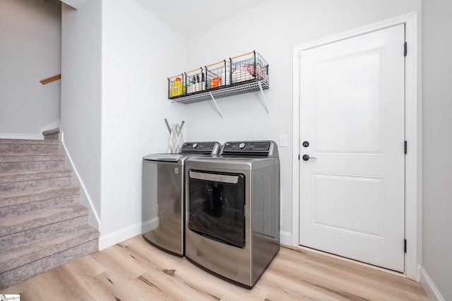 laundry room featuring light wood-style floors, washer and dryer, laundry area, and baseboards