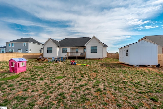 back of property featuring a lawn, a fenced backyard, an outbuilding, crawl space, and a storage unit