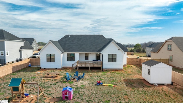 back of house featuring an outbuilding, a storage unit, crawl space, and a fenced backyard