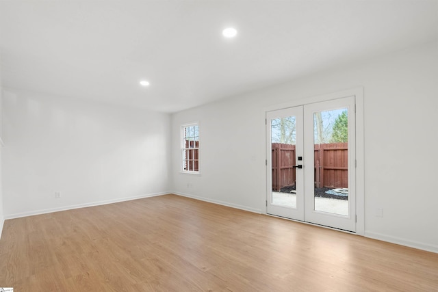 spare room with light wood-style floors, french doors, and baseboards