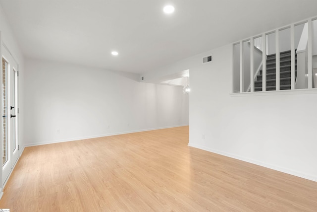 unfurnished room with recessed lighting, visible vents, baseboards, stairs, and light wood finished floors