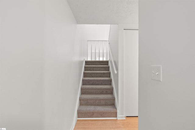 stairway featuring wood finished floors and baseboards