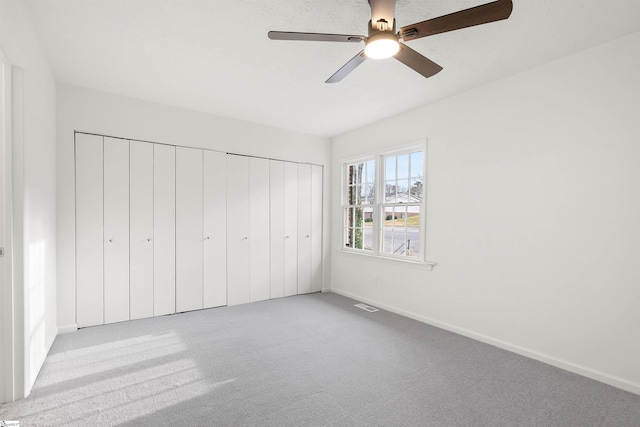 unfurnished bedroom featuring a closet, carpet flooring, visible vents, and baseboards