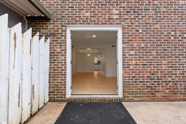 doorway to property with brick siding