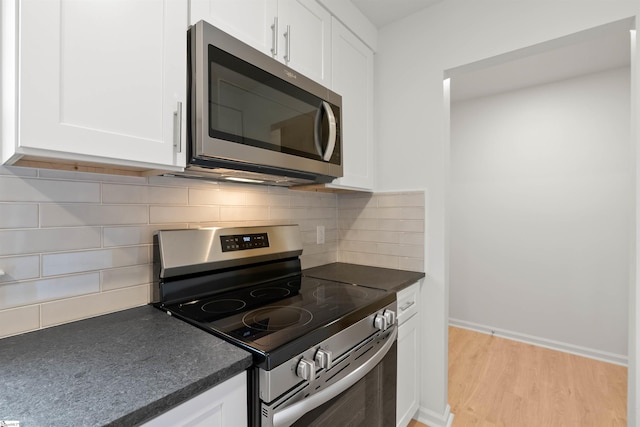 kitchen featuring dark countertops, white cabinetry, and stainless steel appliances