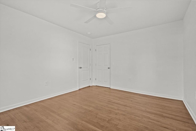 spare room featuring baseboards, a ceiling fan, and wood finished floors