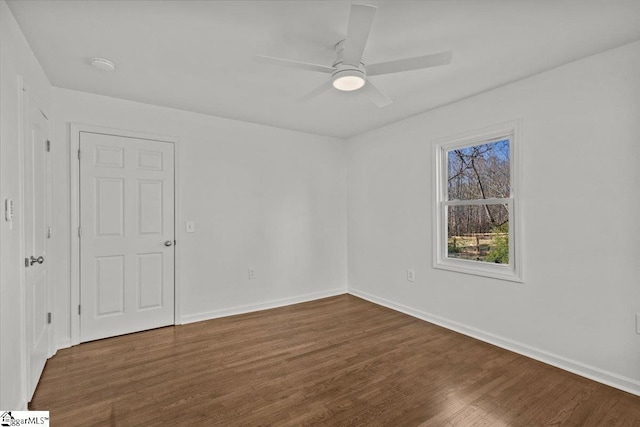 spare room featuring a ceiling fan, baseboards, and wood finished floors