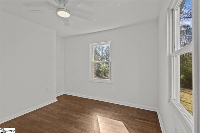 spare room with dark wood-style floors, ceiling fan, and baseboards