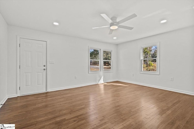 empty room featuring wood finished floors, a ceiling fan, and baseboards