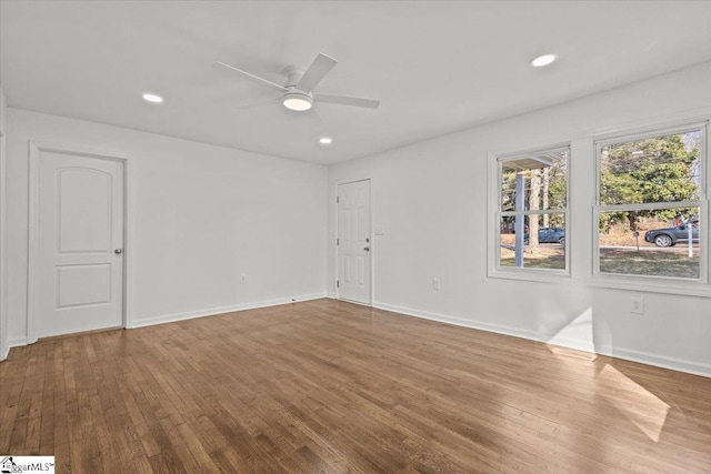 empty room with recessed lighting, wood finished floors, a ceiling fan, and baseboards