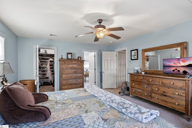 bedroom featuring ceiling fan, visible vents, a closet, carpet, and a walk in closet